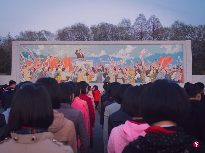 近日，韩国出版金日成抗日运动回忆录《与世纪同行》引发争议。图为2020年11月3日，平壤的青少年在一幅金日成宣传壁画前列队。（Unsplash/Thomas Evans） 