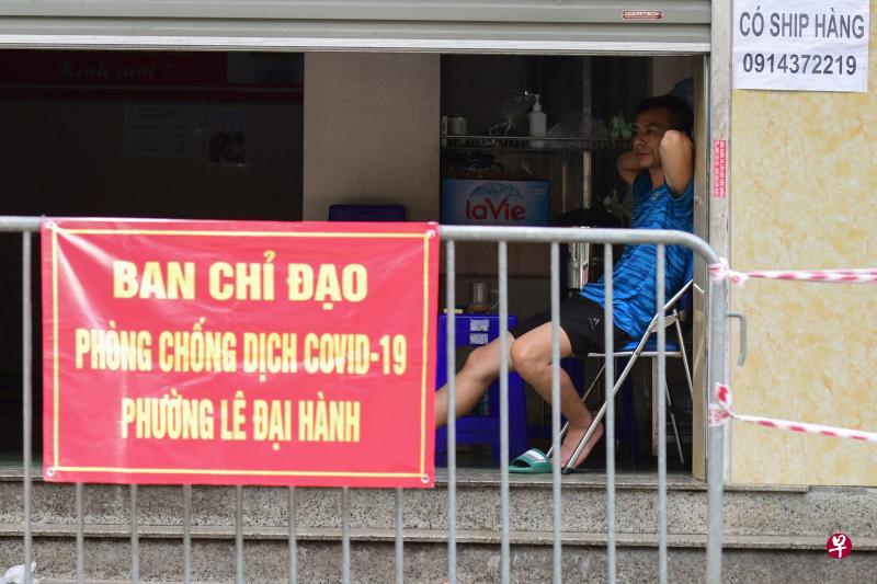 越南河内实施封锁，餐厅不能营业，店主只能闲坐着。（法新社） 