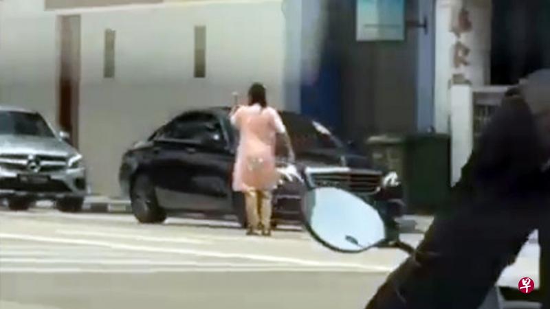 一名年轻女子昨天突然走到劳明达街的路中央“指挥交通”。（取自面簿） 