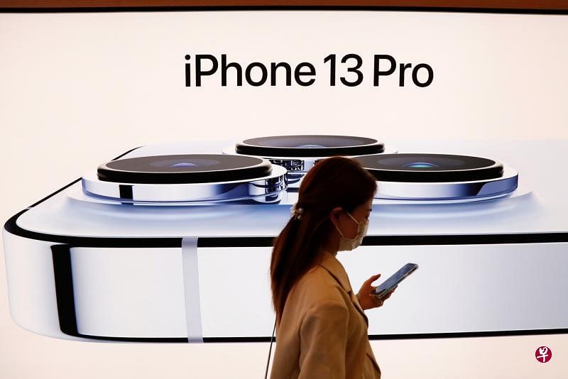 苹果iPhone今年10月份成为中国最畅销的智能手机，是2015年12月以来的首次。图为北京一名市民经过苹果专卖店的广告牌。（路透社） 