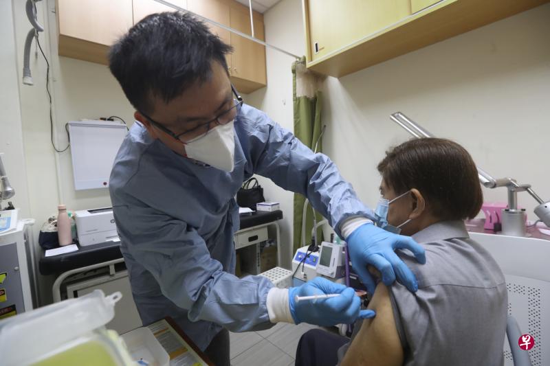 东北医疗集团首席医疗长吴治健医生今早在诊所为85岁的李清成接种第二剂疫苗追加剂。（饶进礼摄） 