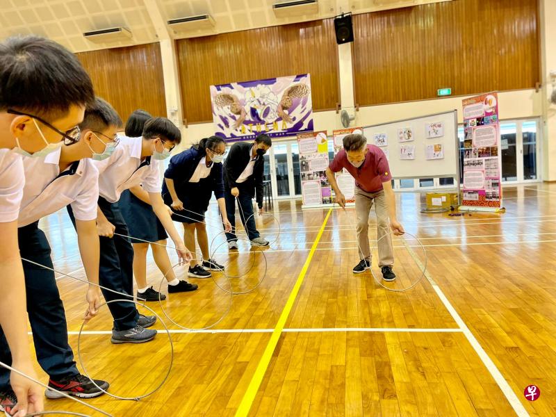 学生正聚精会神地学习滚铁环。（安德逊实龙岗初院提供） 