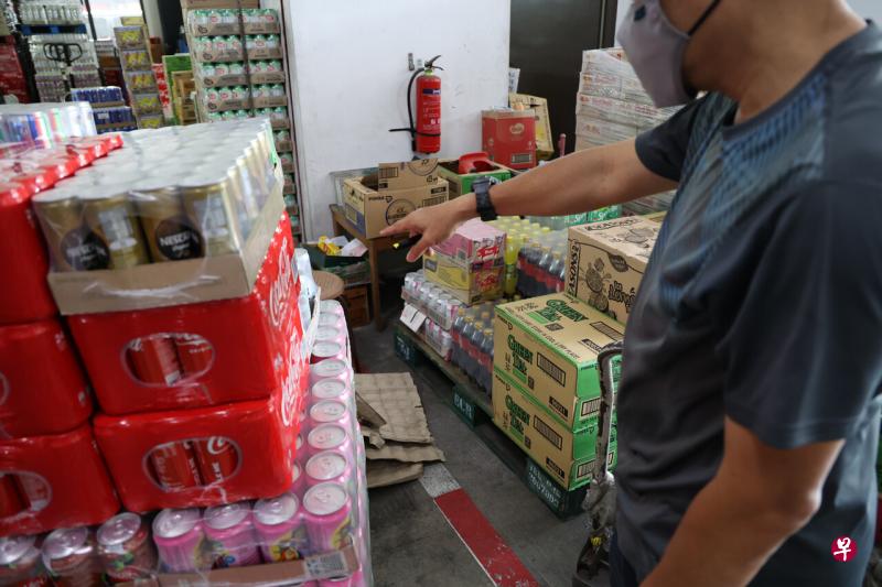 来取货的洪先生发现少了一箱饮料后，马上通知批发商。（吴伟国摄） 