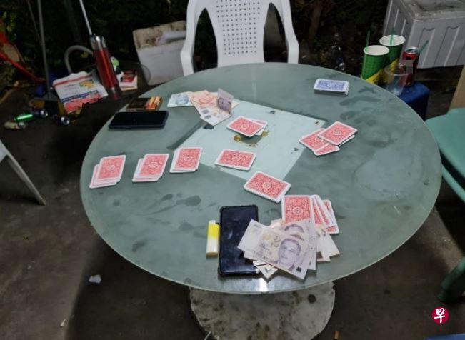 勿洛邻里警局警员在樟宜路的扫荡行动中，搜出258元现金，一台手机赌和赌具。（警方提供） 