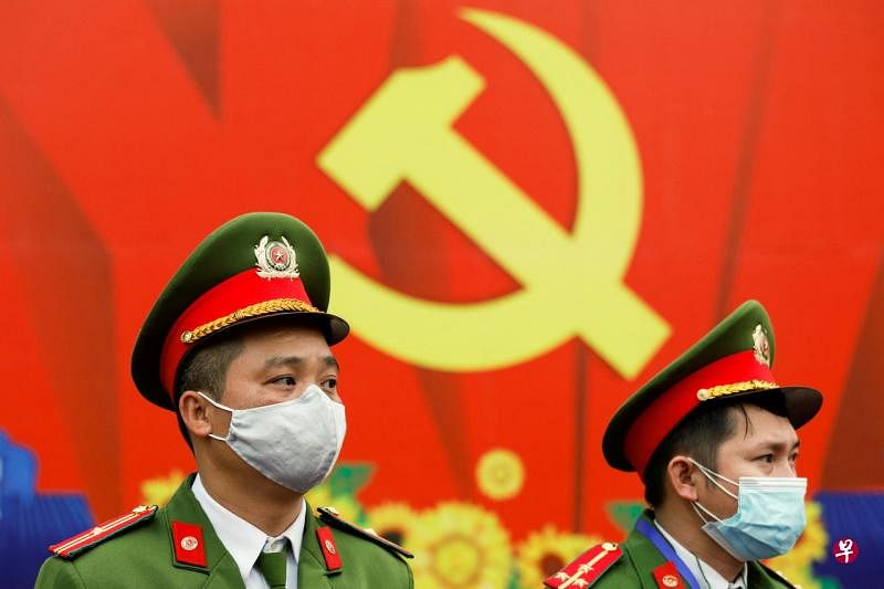 戴着防护口罩的越南警察在国家会议中心的共产党标志前站岗。（路透社） 
