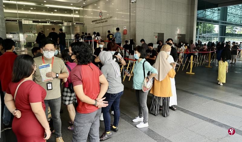 移民与关卡局新规定生效首日，公众须先让工作人员核实是否有收到当局有关办理护照手续的通知或是与当局事先预约好了办理手续的时间，才可开始排队等候进入移民局大厦。（邬福梁摄） 