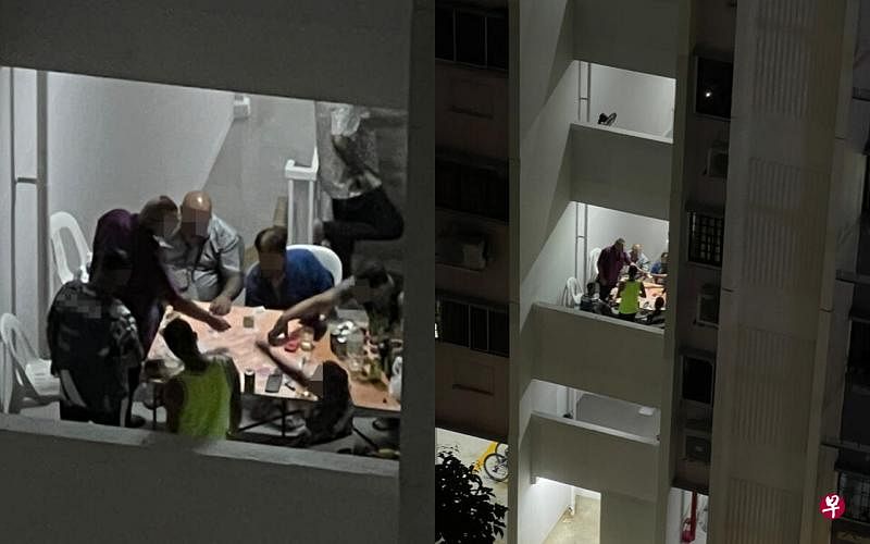一群阿叔深夜在组屋楼梯间摆桌开赌。（受访者提供） 