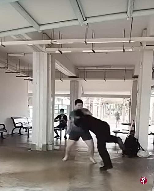 郑福威与青年在组屋底层摔跤比赛。（视频截图）  