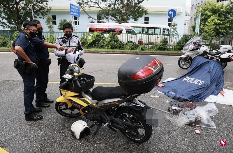电单车不知何故与罗厘相撞，警方在罗厘和电单车附近放置证物牌进行调查。（潘丰源摄） 