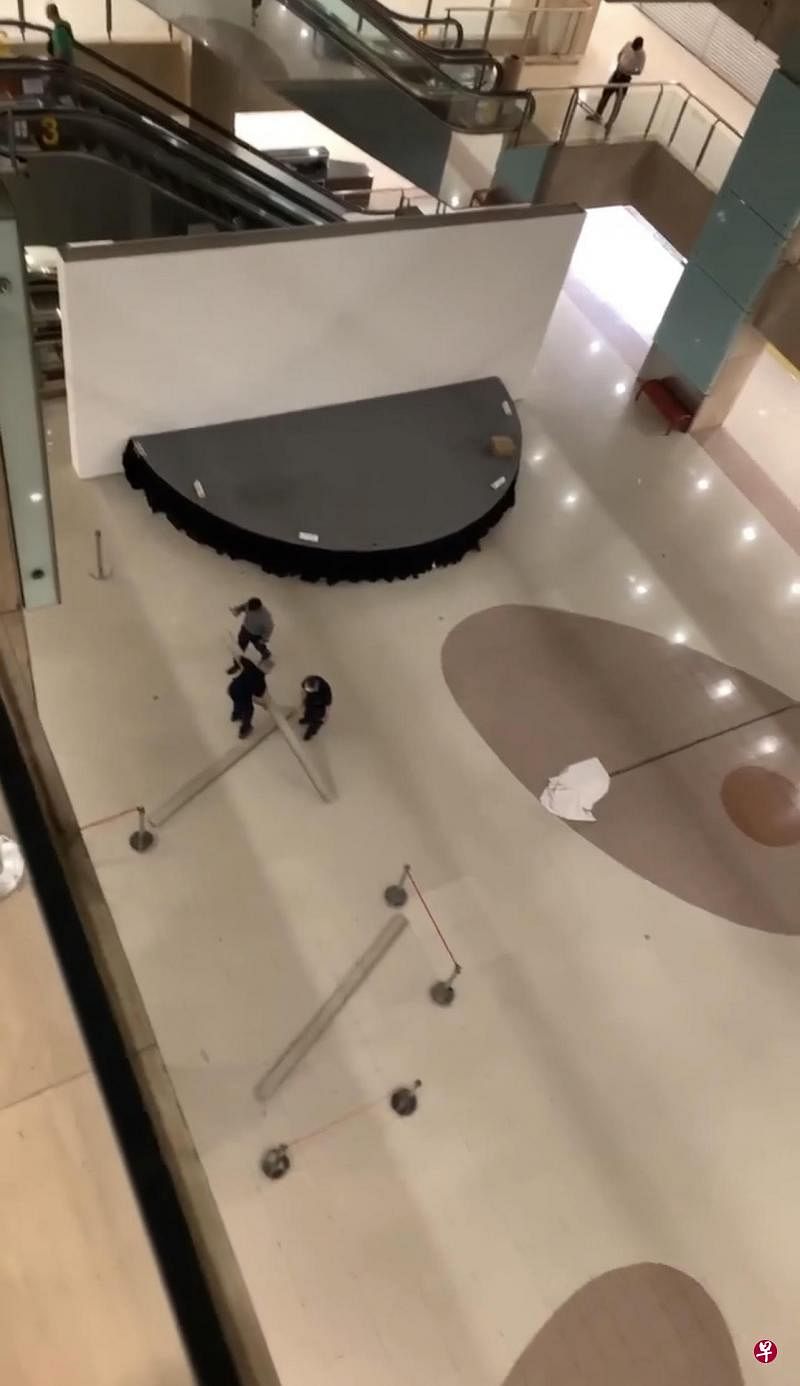 三块木板“从天而降”，幸没人被砸中，三名工作人员清理现场后抬走木板。 （读者提供） 