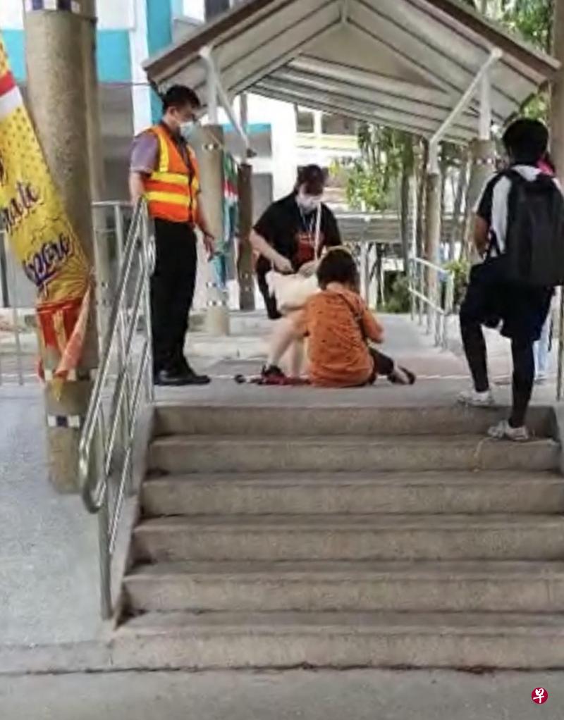 阿嫂跌倒坐在梯级，巴士车长下车帮忙。（读者提供） 