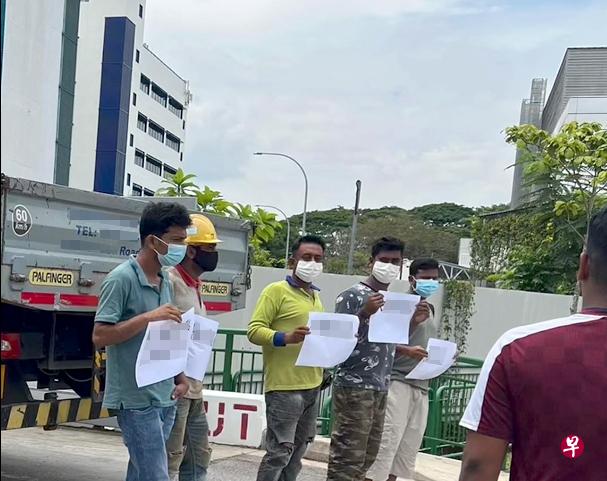 10月18日下午，九名客工来到宏茂桥一家公司门口，举起纸张追讨欠薪。（档案照） 
