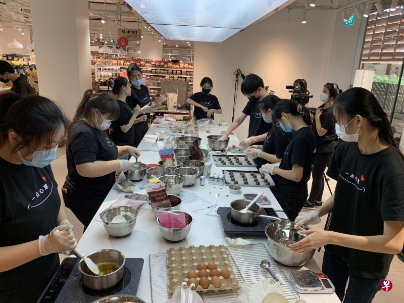 参与“一点心意“活动的义安理工一二年级生和烘焙老师，在八小时内烘制了逾1000个饼干。（蔡铠安摄） 
