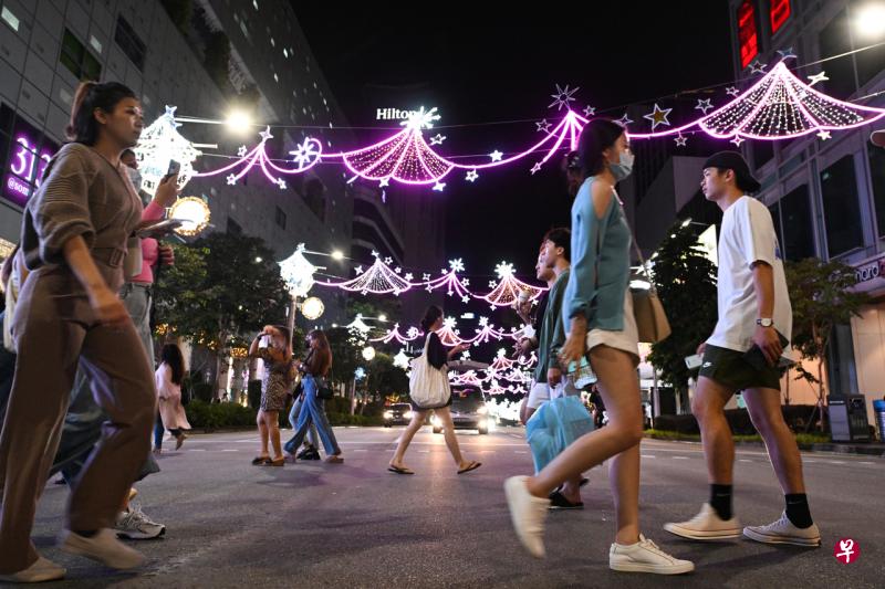 警方在与街头表演者及各相关方沟通后决定，除了平安夜外，麒麟大厦、骑士长廊、文华购物廊和313@Somerset四地点重新允许街头表演。照片摄于11月12日，民众在挂着圣诞灯饰的乌节路313@Somerset外。（海峡时报档案照） 