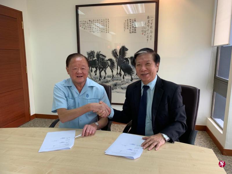 富商黄鸿年（左）和智慧控股集团总裁林焕章（右）在签署新股配售协议后，双方握手致意。（智慧控股提供） 