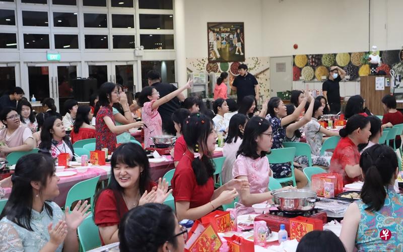 学生们在吃火锅的同时，不忘为台上表演的同学呐喊助威。（周文靖摄） 