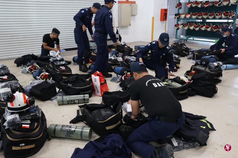 团队成员包括16名灾难拯救队队员、四名救护人员和一名全职国民服役医生。图为成员检查物品，包括即食餐和个人防护装备。（取自民防部队脸书） 