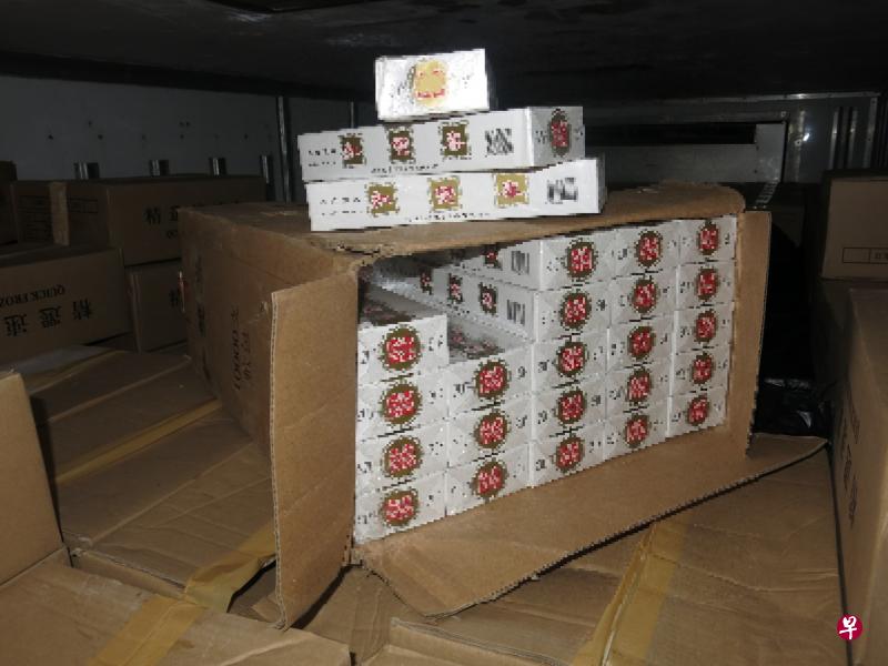 执法人员3月7日在大巴窑工业园一带展开突击行动，并对一辆冷藏卡车进行搜查。之后在卡车后方冷冻柜的一批冷冻鱼货中，搜出6400条漏税香烟。（新加坡关税局提供） 