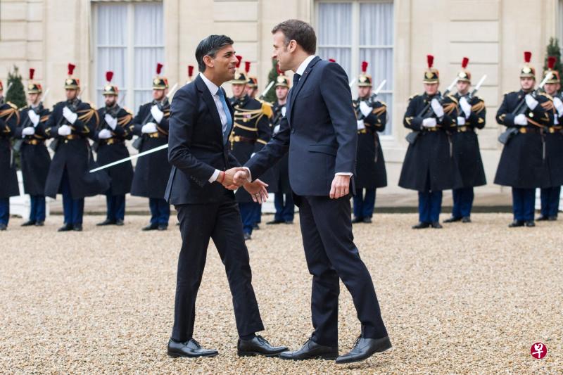 法国总统马克龙（右）在举行双边会议之前欢迎英国首相苏纳克。（彭博社） 