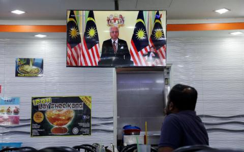 马国首相依斯迈沙比里星期一透过电视与社交媒体直播宣布解散国会。图为吉隆坡市民在餐厅内观看电视直播。（路透社）