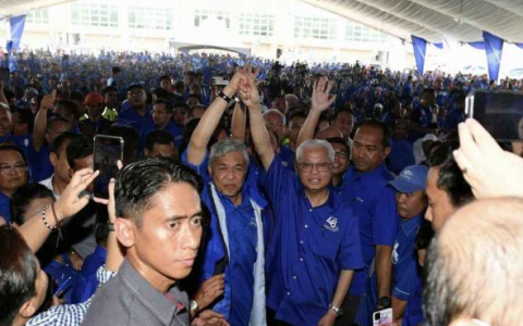 国阵主席阿末扎希及看守首相依斯迈沙比里23日抵达活动会场向支持者示意。（马新社）