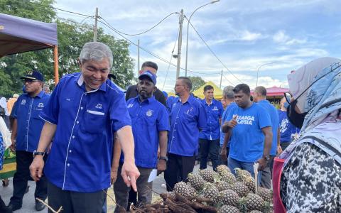 国阵及巫统主席阿末扎希星期一走访他竞选区内的夜市，询问摊贩的生意情况。国阵以解决生活费高涨的压力做为竞选宣言的主轴。（范晓琪摄）