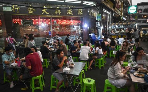 泰国曼谷唐人街小吃摊迎来国内外游客，旅游业和服务业复苏。泰国工商业雇主联合会指出，政党竞选承诺大幅调涨最低日薪，是强迫雇主为政客承诺买单，最终受影响的还是消费者。（法新社）