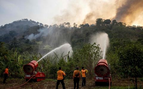 旱季容易引发林火，导致泰国多个地区的空气污染指数都超标。图为消防员3月31日在中部那空那育府的一座山边尝试扑灭林火。（法新社）