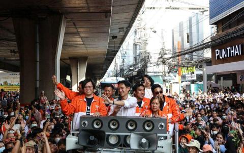 前进党党魁披塔（白衣者）5月18日在曼谷街头谢票。前进党已不要求执政联盟成员党必须支持修改冒犯君主法。（彭博社）