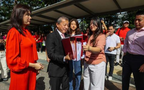 企业家吴振华（左二）与妻子（左一）和四名孩子，星期五早上现身选举局，提交厚厚的文件和总统候选人合格证书申请表格。（白艳琳摄）