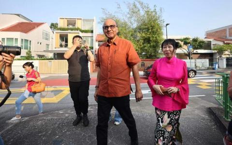 总统候选人尚达曼（中）与夫人珍一藤木（右一），9月1日下午到莱佛士女子小学投票站投票。（陈渊庄摄）