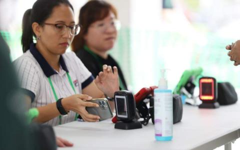 一些选民在投票站，通过Singpass应用上的数码身份证验证身份后，顺利投票给心目中的总统人选。这是我国第一次在选举中使用数码身份证。（蔡家增摄）