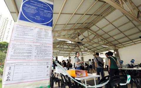 大巴窑5巷第63座组屋凉亭的投票站，是全岛1264个投票站之一。工作人员星期四下午到场布置，包括张贴告示牌，排列桌椅等。（邝启聪摄）