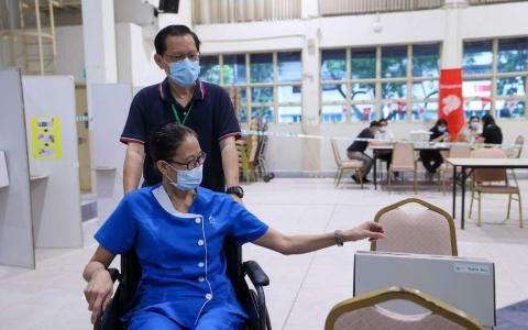 安老协会在院内的多功能厅设立特别投票站，使用轮椅的住户在工作人员的安排下，到投票站领取选票，并在适合轮椅用户高度的投票区投下神圣的一票。（白艳琳摄）