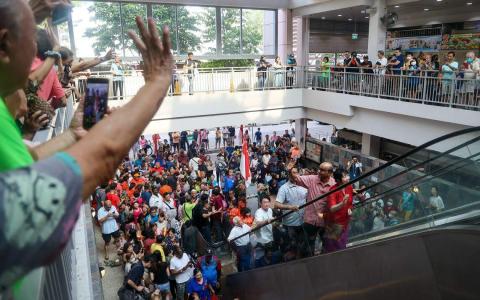 当选总统尚达曼与夫人珍一藤木（电扶梯上）星期六（9月2日）早上到达曼裕廊巴刹与熟食中心谢票，大批民众聚集在现场等候。（陈渊庄摄）
