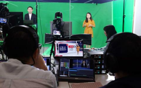 虚拟摄影棚技术让新闻团队突破了实体影棚的空间局限，在内容与视觉设计上拥有更多发挥空间。（白艳琳摄）