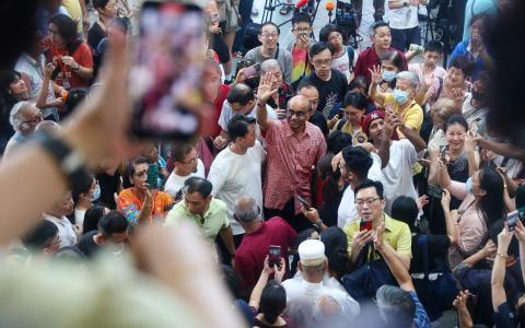 在第六届民选总统选举中胜出的前国务资政尚达曼（红衣挥手者），星期六中午到大巴窑中心答谢选民的支持。他一出现就有许多民众大声欢呼鼓掌。（陈渊庄摄）