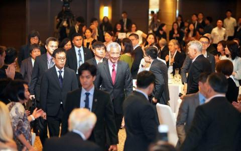 李显龙总理（中，系红领带）莅临“亚洲前瞻峰会2023”会场。在李总理右手边的是在新报业媒体英文、马来文与淡米尔文媒体集团总编辑黄维光。（谢智扬摄）