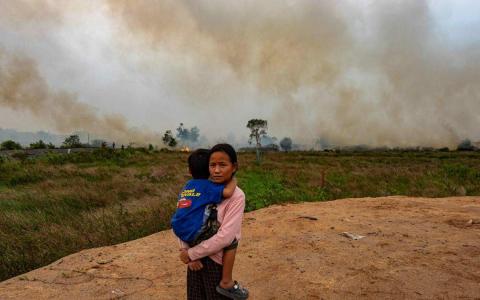 印尼几个省份的林火产生烟霾，邻近国家也都遭殃。图为星期三（10月4日）南苏门答腊首府巨港林火迟迟未被扑灭，严重影响当地居民的生活及健康。（法新社）