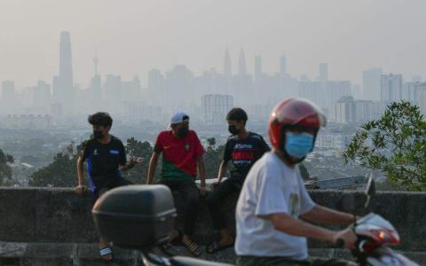 马国星期二空气素质没有明显改善，吉隆坡蕉赖的空气污染指数仍处于162点的不健康水平。吉隆坡一些民众外出时戴上口罩。（马新社）