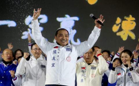 国民党总统候选人侯友宜（中）去年12月23日在台北出席造势活动时，热情地向支持者挥手致意。（法新社）