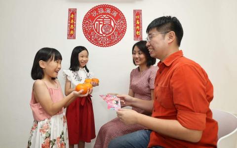 张美芳（右二）与林玉祥利用新年长辈给小孩红包的机会，教导孩子理财。（陈渊庄摄）