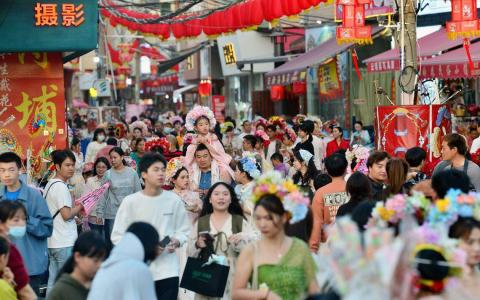 农历新年期间，福建泉州蟳埔民俗文化村挤满前去体验当地“簪花围”民俗装扮的游客，接待游客量和旅游收入均创下历史新高。中国异常火爆的春节旅游市场，带动整体消费增长远超预期。（中新社）