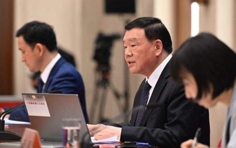 中国十四届全国人大二次会议新闻发言人娄勤俭（中）星期一说，今年两会闭幕后不会举行总理记者会。（法新社）