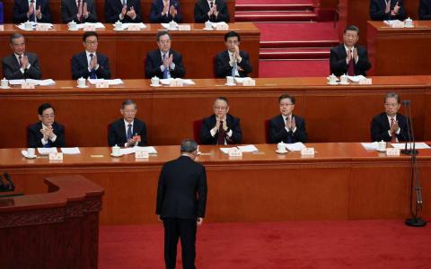 台湾学者分析，从取消总理记者会到修订《国务院组织法》，中共将进一步强化以党领政结构，国务院总理已转变为“忠诚的政策执行者”。图为中国总理李强（前）3月5日在全国人大开幕式上宣读政府工作报告后，向台上的中国国家主席习近平等人鞠躬。（路透社）