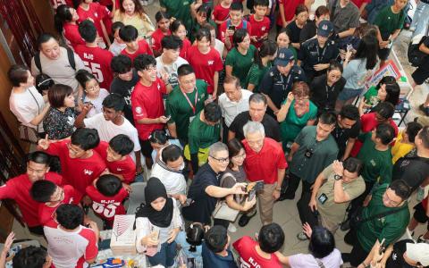 李显龙总理（中）5月11日上午回母校国家初级学院支持Funtasia嘉年华，参观展摊和活动。（李冠卫摄）