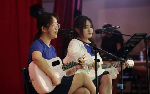 “M&C”组合的魏美帆（左）与陈晨（右）自弹自唱《小人物的心声》完成跨校合作。（梁麒麟摄）