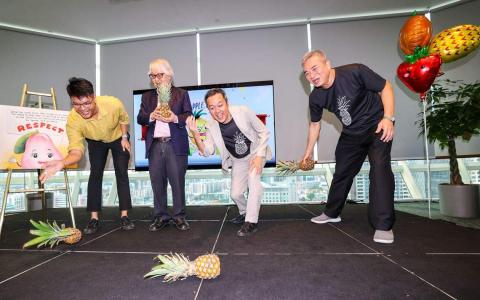 新加坡巡回大使许通美（左二）担任《翻滚吧，黄梨》（Pineapple, Let’s Roll!）新书发布会的主宾，与执笔人白胜晖（右二）、插画家郭宏驯（左一），以及活动嘉宾达曼裕廊公民咨询委员会主席、尚达曼竞选团队主席黄光明（右一）一起在地上滚黄梨。黄梨是尚达曼总统的竞选标志。（陈斌勤摄）