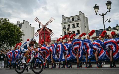 法国公路脚踏车选手马杜耳斯经过表演法国康康舞的舞者。（法新社）