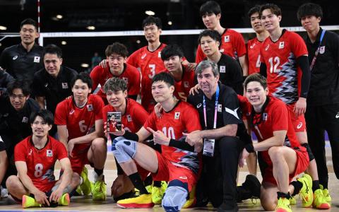 日本男排赛后拿着藤井直伸的照片拍大合照。（路透社）